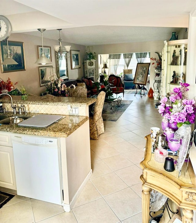 kitchen featuring sink, light tile floors, hanging light fixtures, white cabinets, and white dishwasher