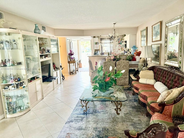 tiled living room featuring a notable chandelier and a textured ceiling