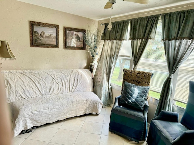 tiled living room with plenty of natural light and ceiling fan