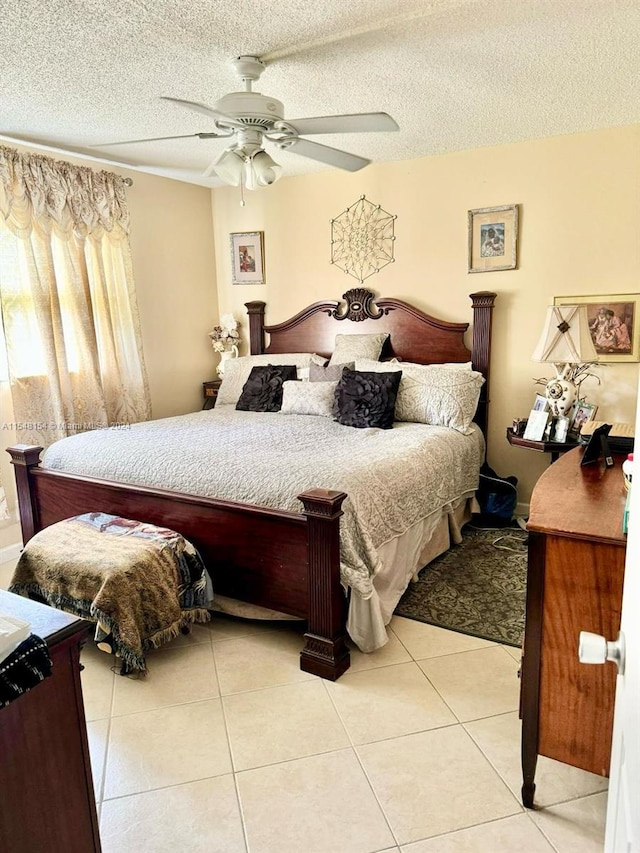 tiled bedroom featuring ceiling fan and a textured ceiling