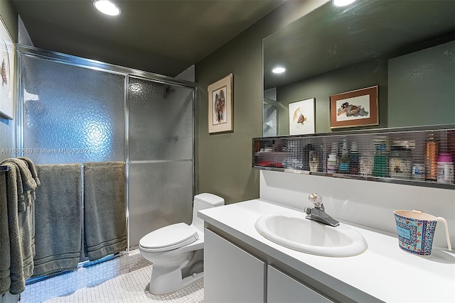 bathroom featuring tile floors, a shower with shower door, vanity with extensive cabinet space, and toilet