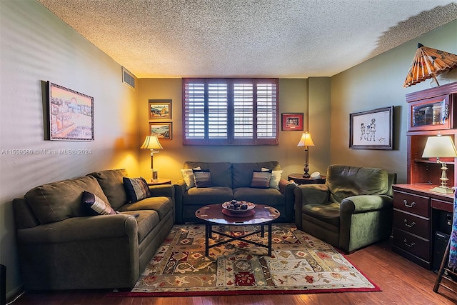 living room with dark hardwood / wood-style flooring and a textured ceiling