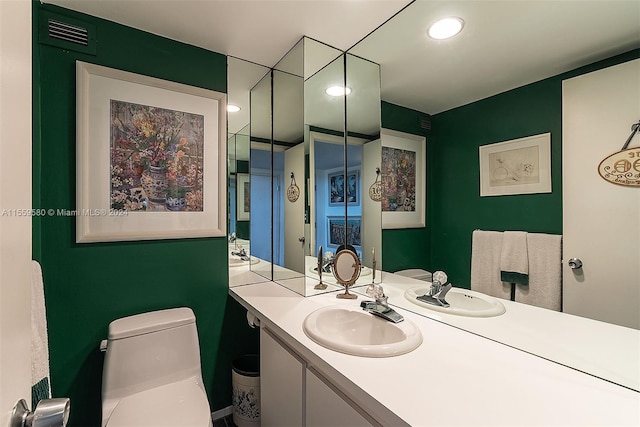 bathroom featuring toilet and vanity with extensive cabinet space