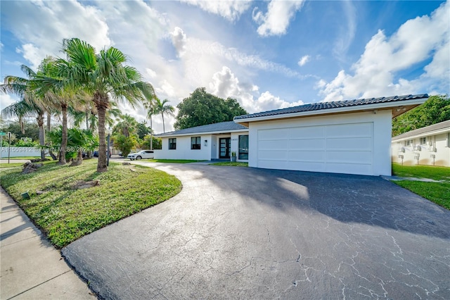 single story home with a front yard and a garage