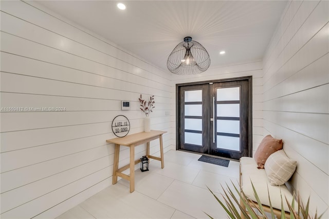 interior space with wood walls, tile flooring, and french doors