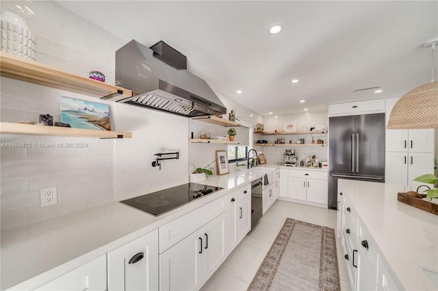 kitchen with white cabinets, high end fridge, light tile flooring, and island range hood