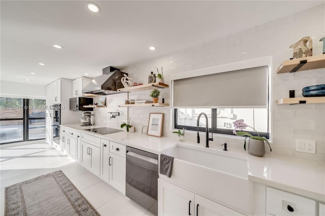 kitchen with white cabinetry, appliances with stainless steel finishes, wall chimney exhaust hood, backsplash, and light tile floors