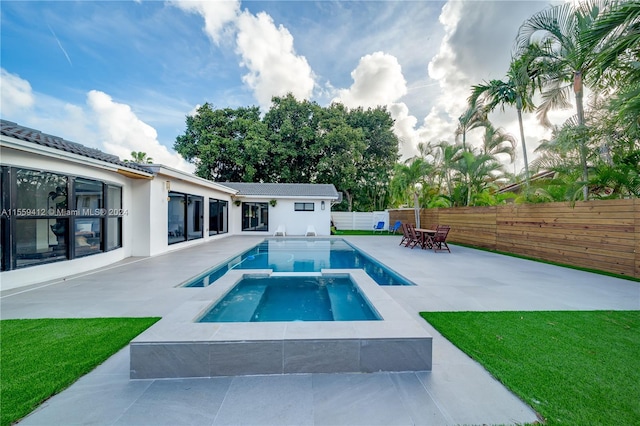 view of pool with a lawn, an in ground hot tub, and a patio