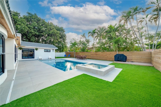 view of pool with a patio, a lawn, and an in ground hot tub