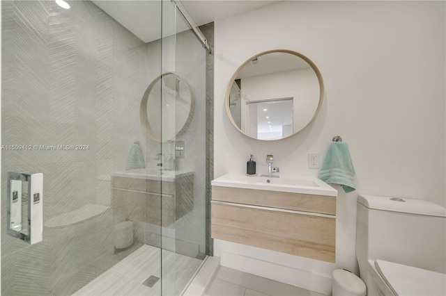 bathroom featuring a shower with shower door, tile flooring, oversized vanity, and toilet