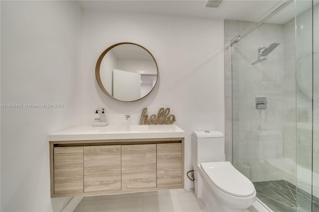 bathroom with a shower with door, tile flooring, toilet, and vanity