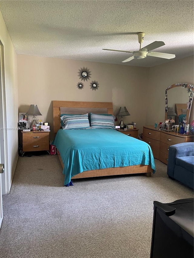 carpeted bedroom with a textured ceiling and ceiling fan