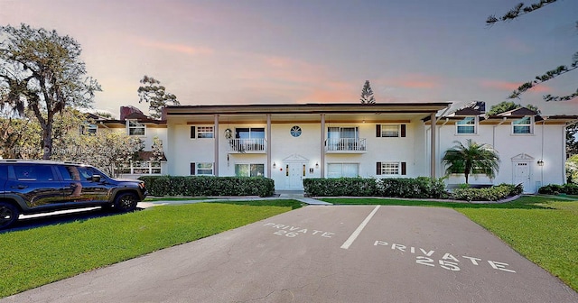 view of front of home featuring a balcony and a lawn