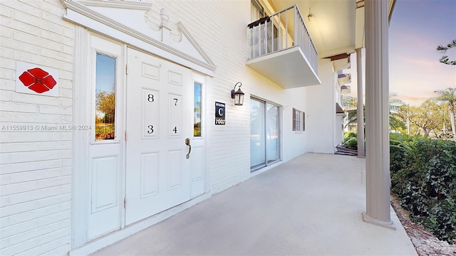 exterior entry at dusk with a balcony