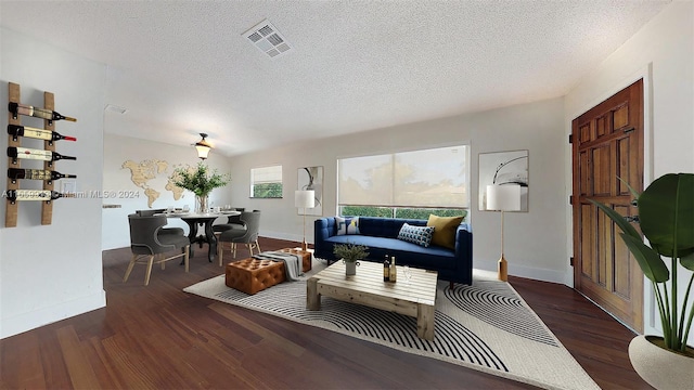 living room with a textured ceiling, dark hardwood / wood-style floors, and vaulted ceiling