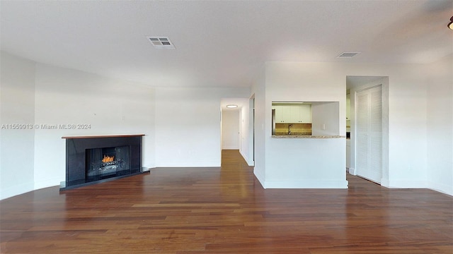 unfurnished living room featuring dark wood-type flooring