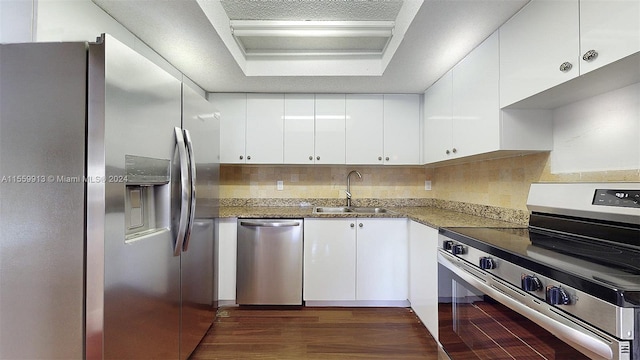 kitchen featuring dark wood-type flooring, tasteful backsplash, white cabinets, stainless steel appliances, and sink