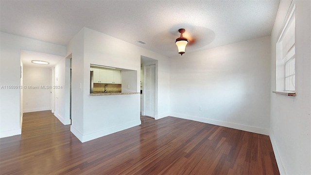 interior space with a textured ceiling and dark wood-type flooring