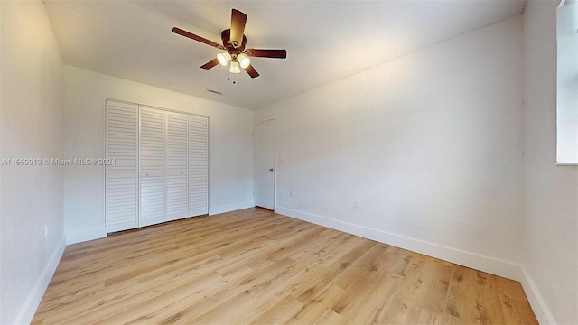 unfurnished bedroom featuring light hardwood / wood-style flooring, ceiling fan, and a closet