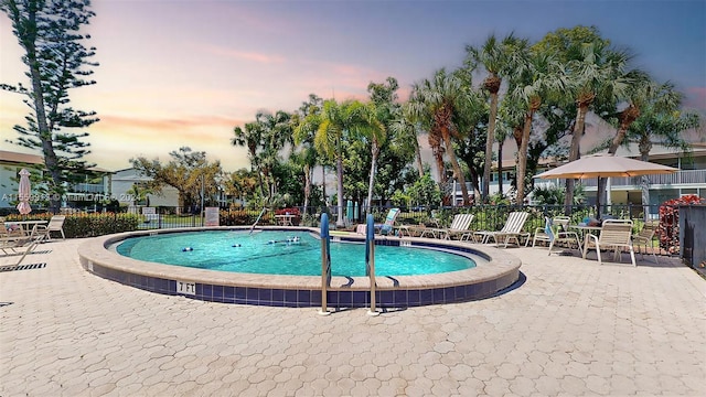 pool at dusk with a patio