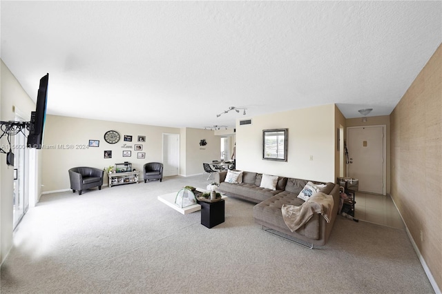 living room with track lighting, carpet, and a textured ceiling