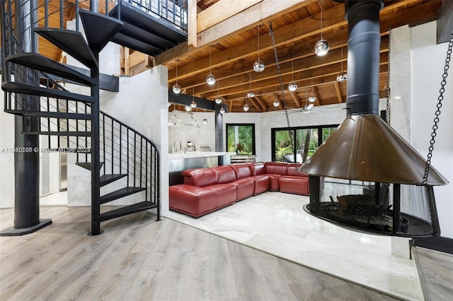 living room with high vaulted ceiling, beamed ceiling, a wood stove, wooden ceiling, and wood-type flooring