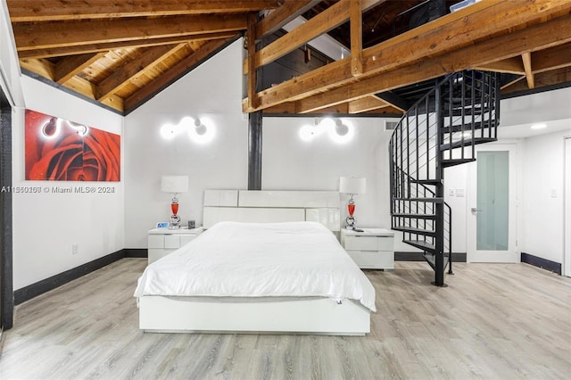 bedroom featuring light wood-type flooring, wood ceiling, beam ceiling, and high vaulted ceiling