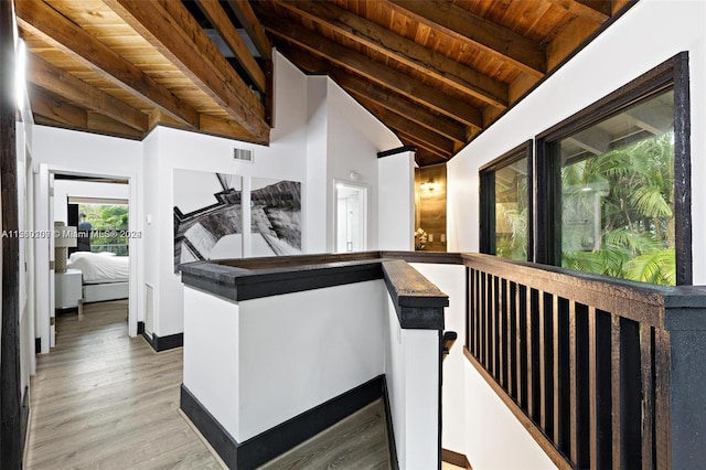 interior space featuring wooden ceiling, light wood-type flooring, and lofted ceiling with beams