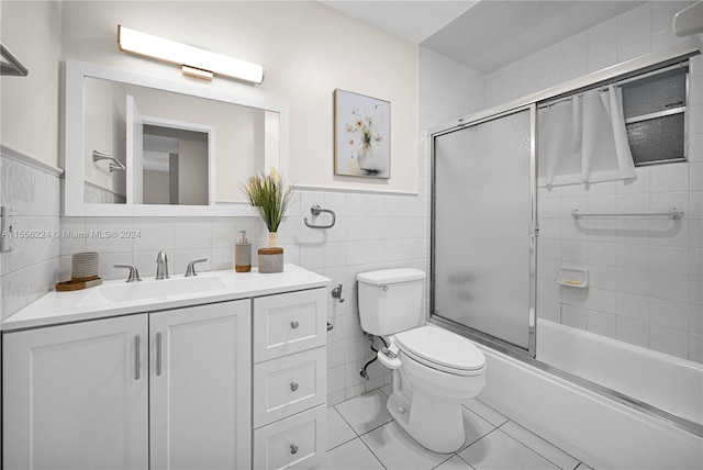 bathroom featuring vanity, toilet, tile patterned floors, and tile walls