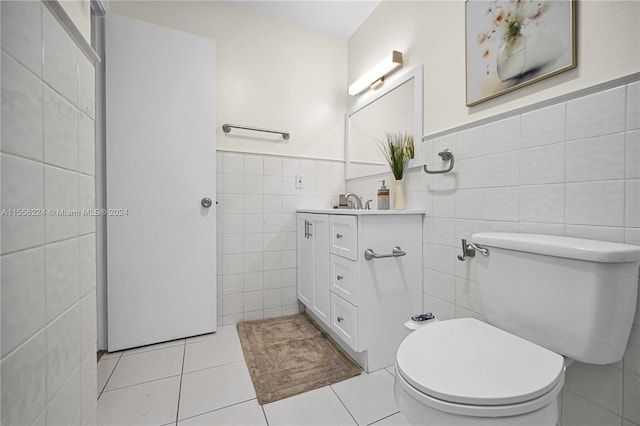 bathroom featuring tile patterned floors, toilet, tile walls, and vanity