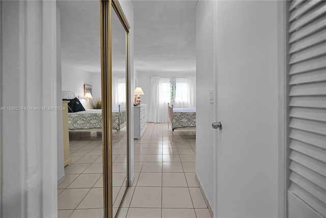 corridor with light tile patterned floors and a textured ceiling