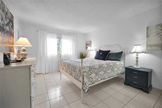 bedroom featuring a textured ceiling and light tile patterned floors