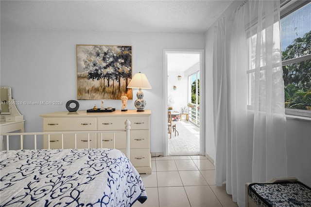 bedroom featuring light tile patterned floors and a textured ceiling