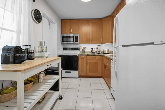 kitchen with light stone counters, white appliances, decorative backsplash, and light tile patterned floors