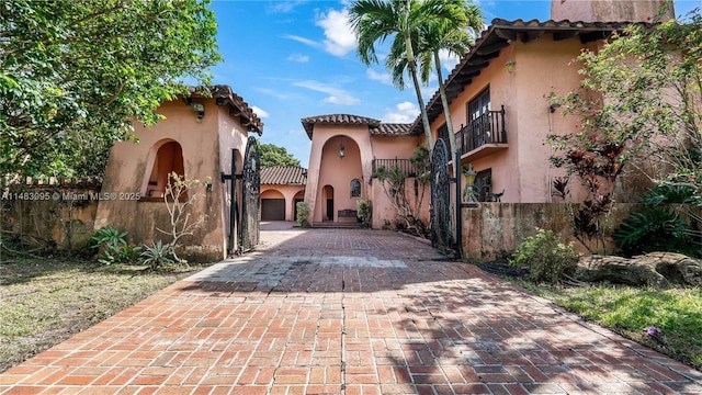 view of road with decorative driveway and a gate