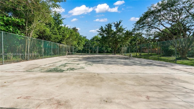 view of home's community with a tennis court and fence