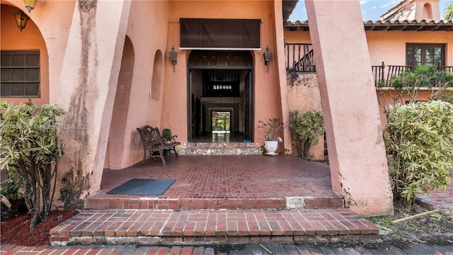 entrance to property featuring a tile roof and stucco siding