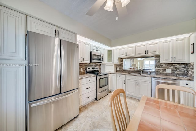 kitchen with ceiling fan, stainless steel appliances, light tile flooring, and white cabinets