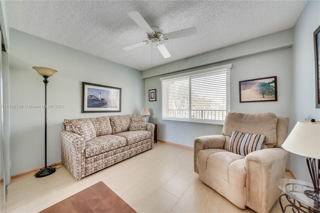 living room featuring a textured ceiling, light hardwood / wood-style floors, and ceiling fan