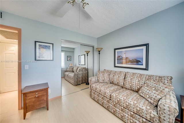 living room featuring a textured ceiling and ceiling fan