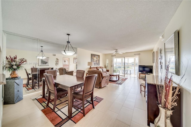 tiled dining area featuring ceiling fan and a textured ceiling