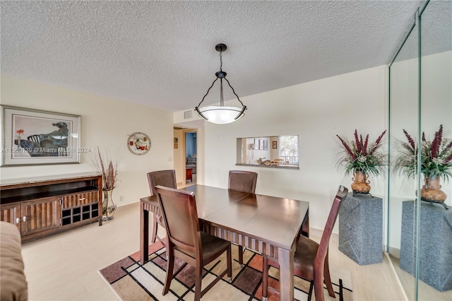 dining room with light tile flooring and a textured ceiling