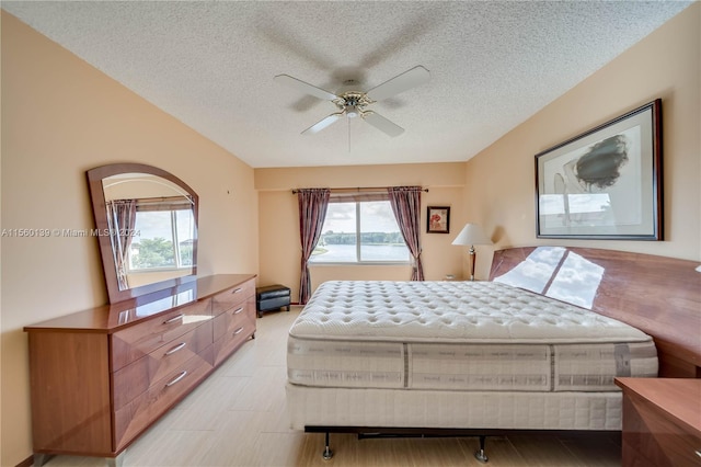 bedroom with a textured ceiling, multiple windows, and ceiling fan