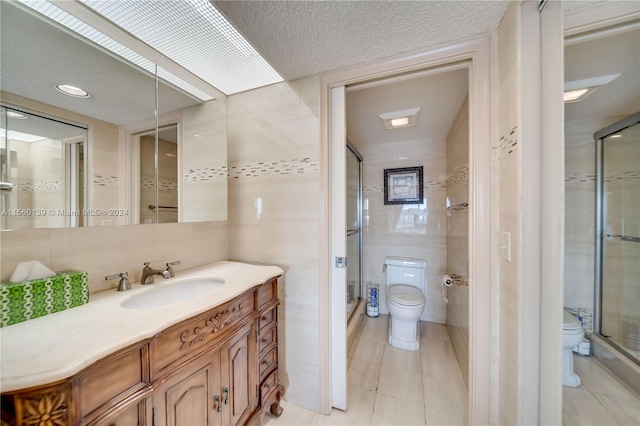 bathroom featuring toilet, tile flooring, a textured ceiling, and vanity