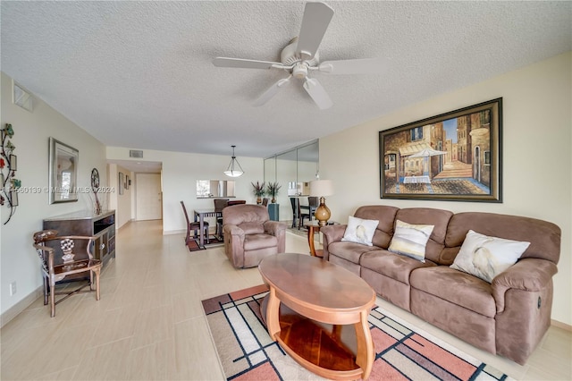 tiled living room with a textured ceiling and ceiling fan