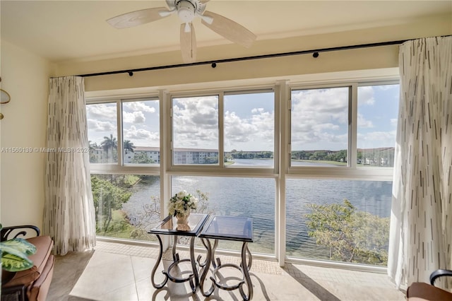 sunroom / solarium with a water view and ceiling fan