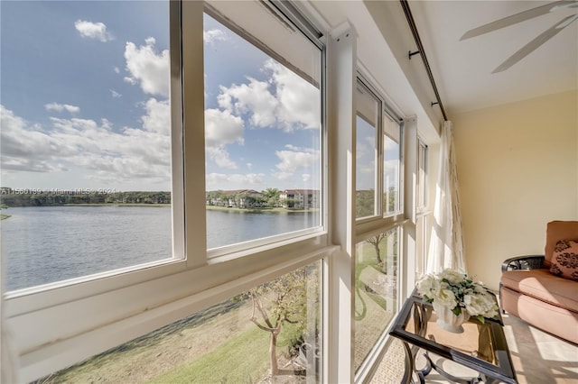 sunroom / solarium with a water view, ceiling fan, and a wealth of natural light