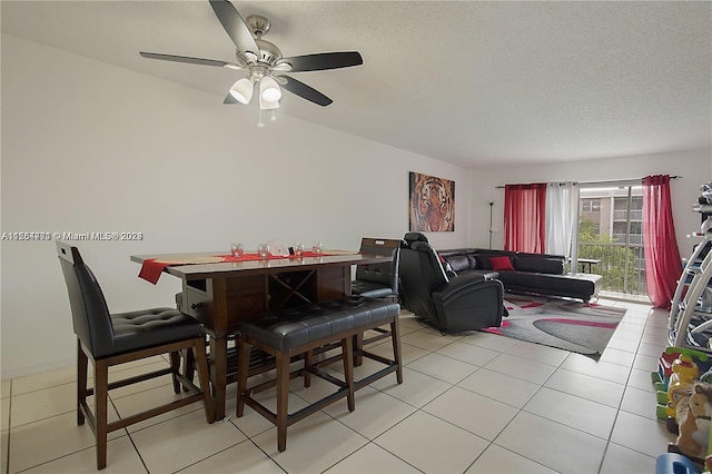 tiled dining room featuring ceiling fan and a textured ceiling