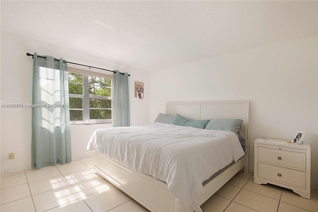 tiled bedroom featuring a textured ceiling