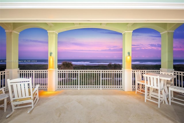 patio terrace at dusk featuring a water view